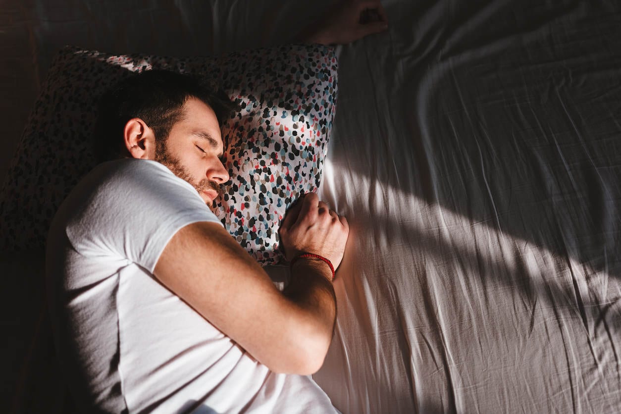 Young man sleeping in the bed in the morning