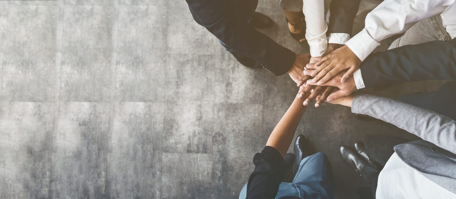 Unity and teamwork. Business people putting their hands together, top view, copy space