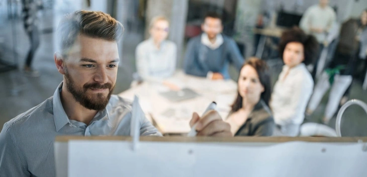 Young Businessman Writing Ideas on a Whiteboard during a brainstorming session