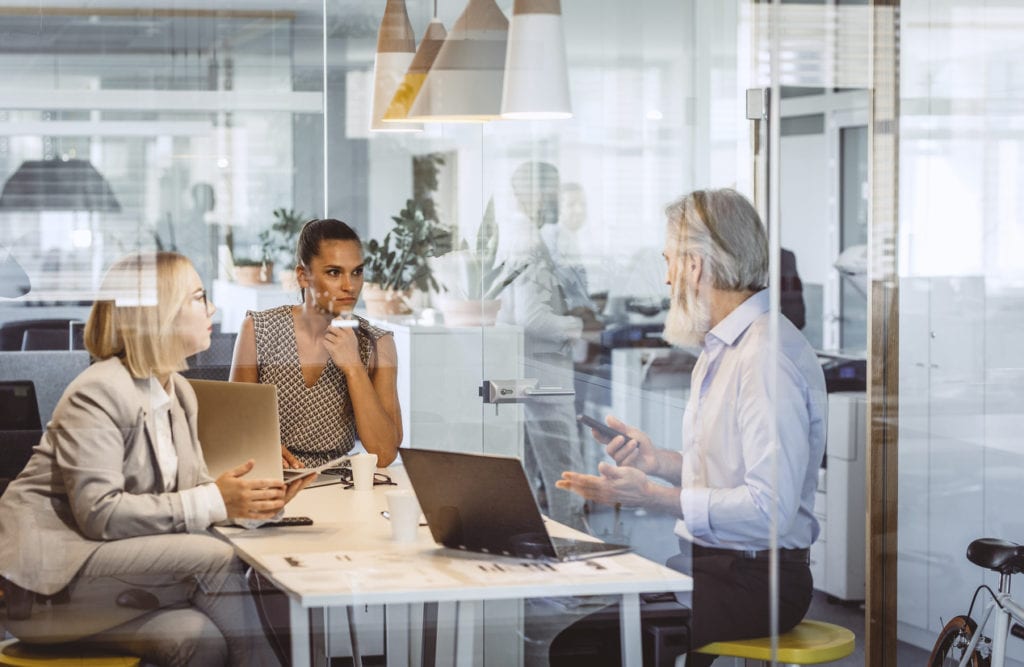 Business People Sitting at Desk, Discussing