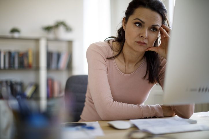 Worried businesswoman looking at computer screen