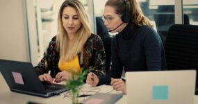 Two female employees looking at a computer screen working between themselves