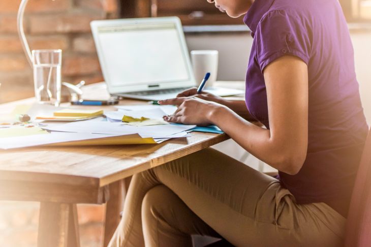 Cropped photo of womens body writing notes on paper