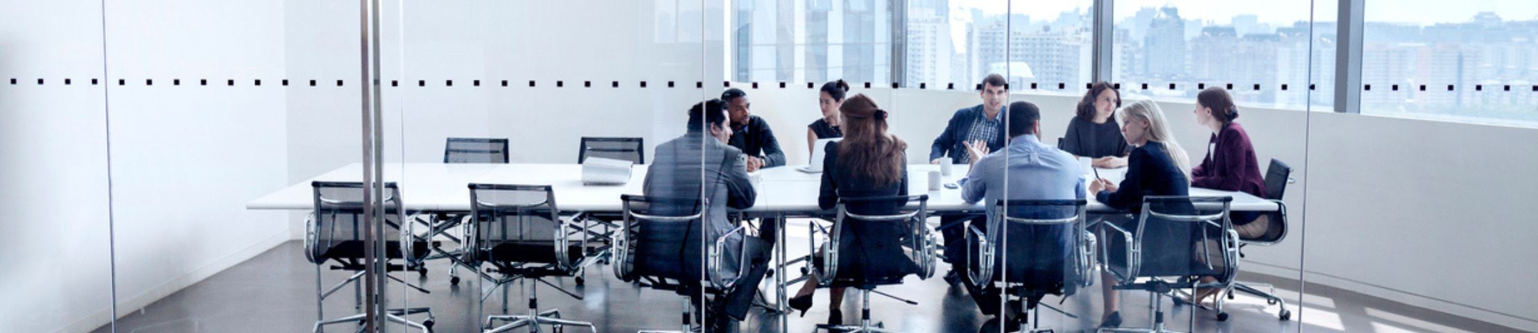 Nine Employees in glass office having a meeting