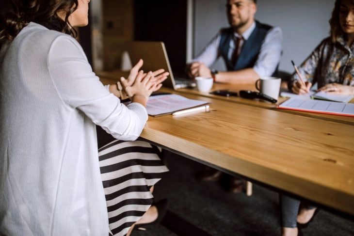 cropped image of a job interview taking place on a wooden table