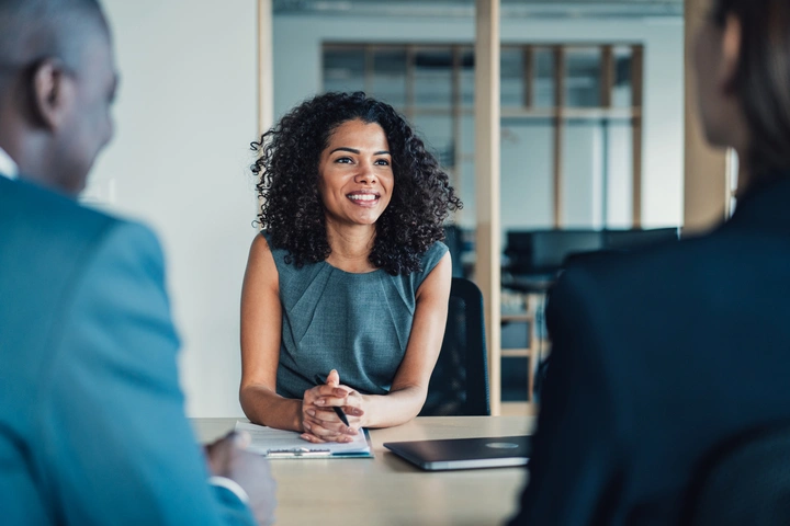 Photo of a young business women during a job interview with blurred out employers in front of her