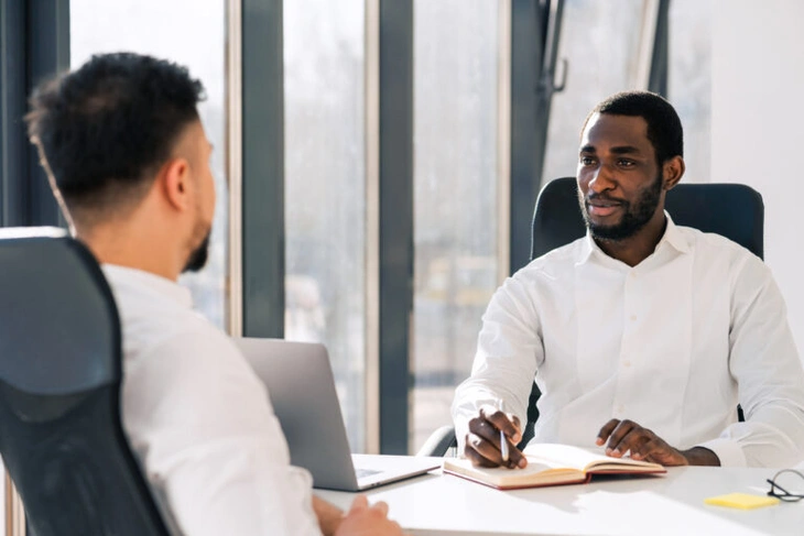 young dark skinned business man interviewing job candidate