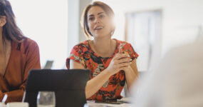 Attractive female employee sitting at meeting table looking thoughtful, ideas, strategy, focus