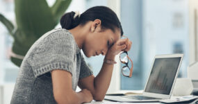 Shot of a young businesswoman looking stressed out while working in an office