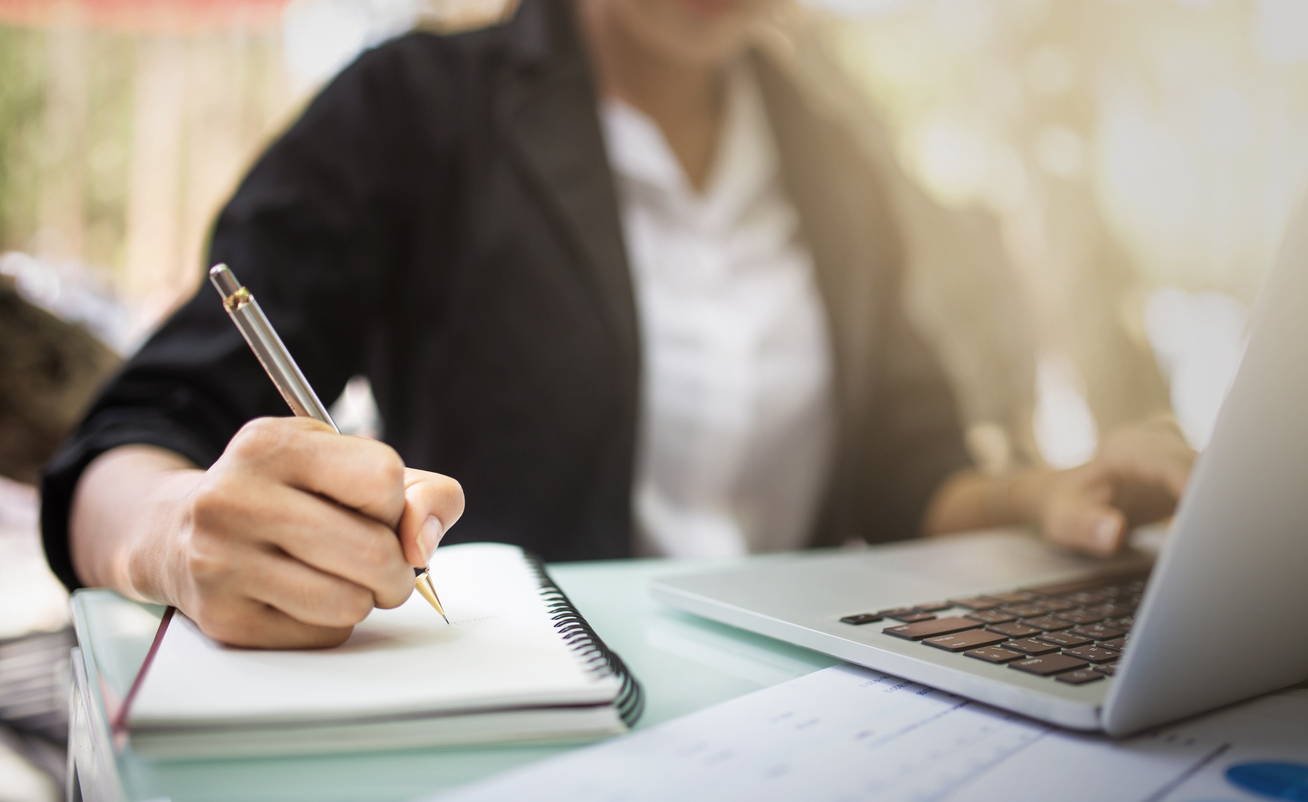 Cropped image of a women's hands writing on a notepad