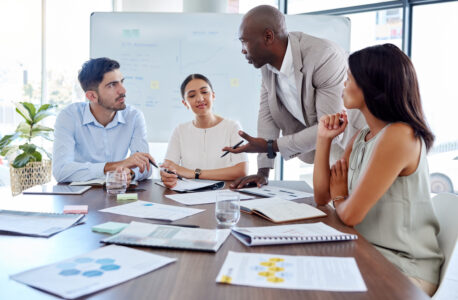 group of four employees speaking between themselves at the meeting table