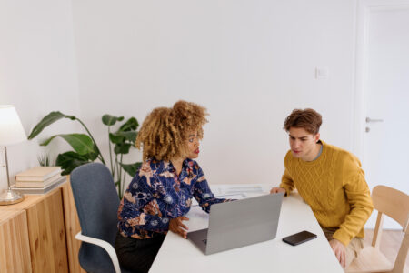 Female boss showing something to prospect on a laptop