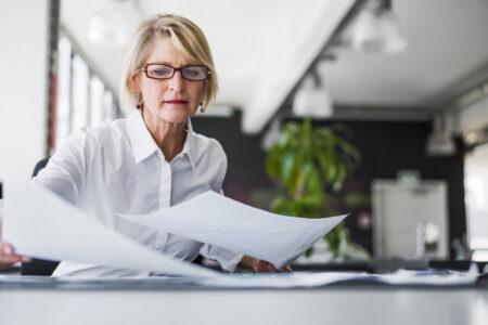 Older corporate women looking at paper 