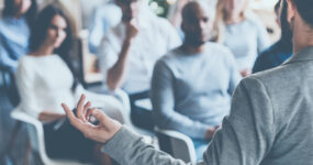 Photo of a crowd of co workers engaged in a presentation