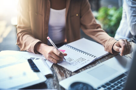 Cropped photo of a female writing notes in a paper pad