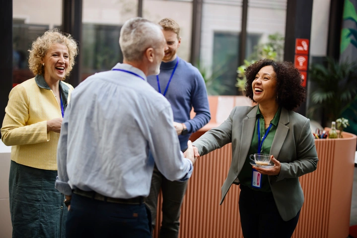 man and women shaking hands greeting each other at a networking event