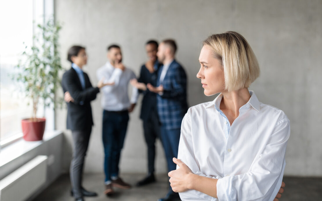 Female employee with her back turned to her coworkers