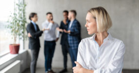 Female employee with her back turned to her coworkers