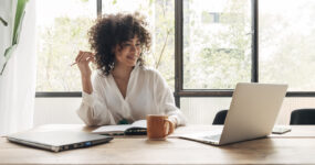 Women on laptop in bright office smiling