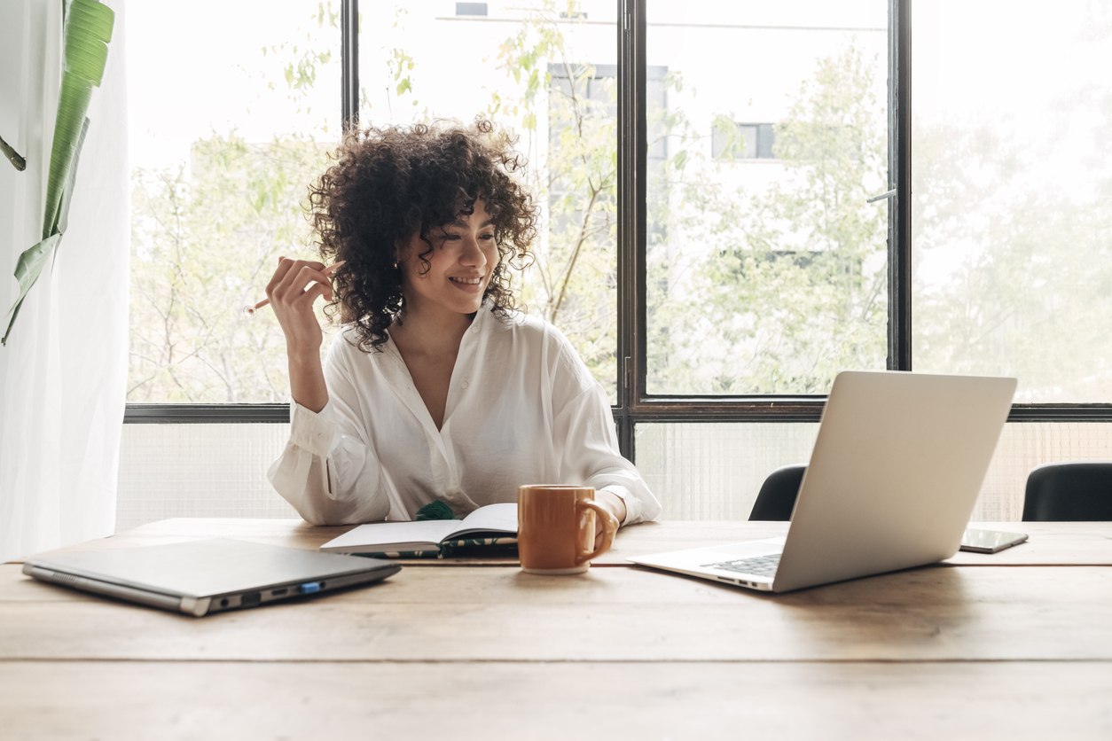 Women on laptop in bright office smiling