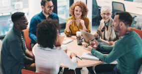 Mixed group of business people sitting around a table and talking