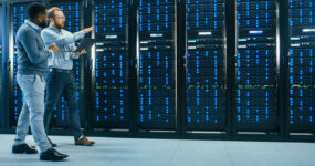 Two males walking alongside servers