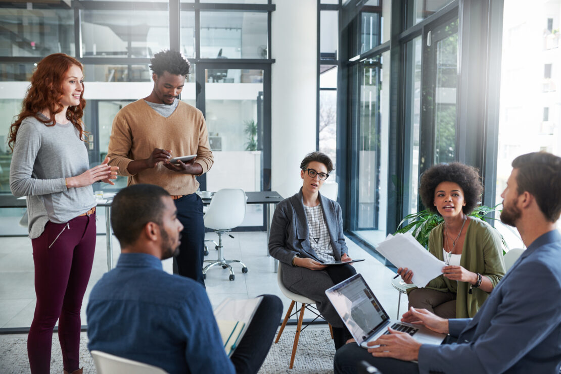 Group of employees gathered around for a meeting