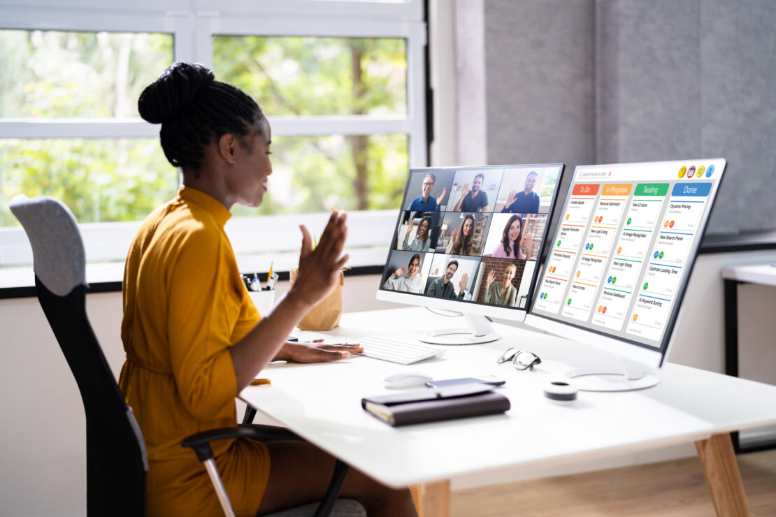 Female on work at home desk whilst being on a work call and analysing the project management tool