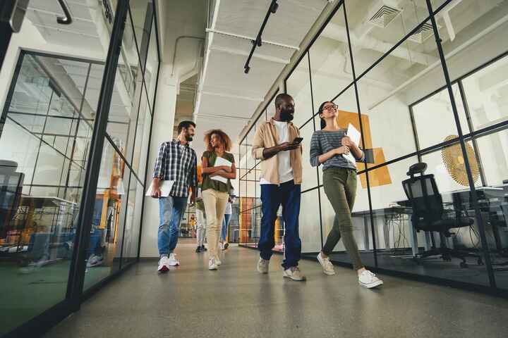 Corporate team walking down office hallway to meeting room