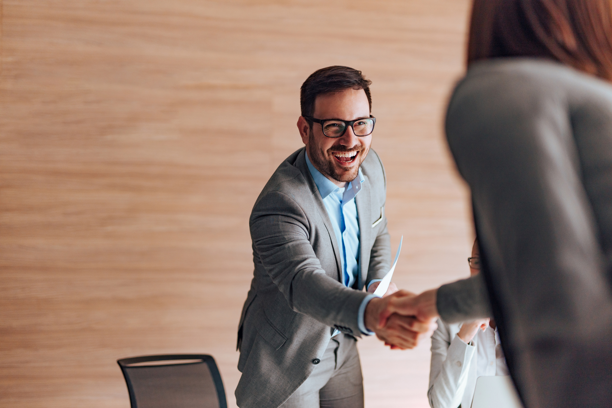 man shaking woman's hand in interview